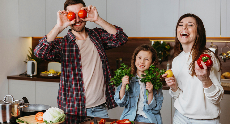 Family holding food and smiling at the camera